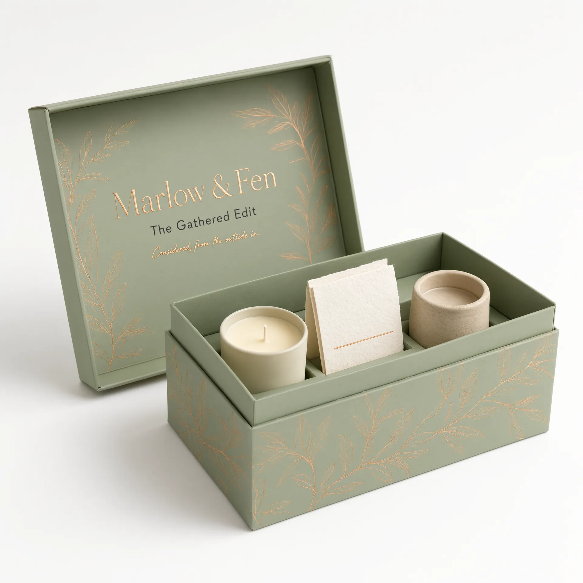 Open sage green rigid gift box showing a candle, card, and jar in a fitted tray