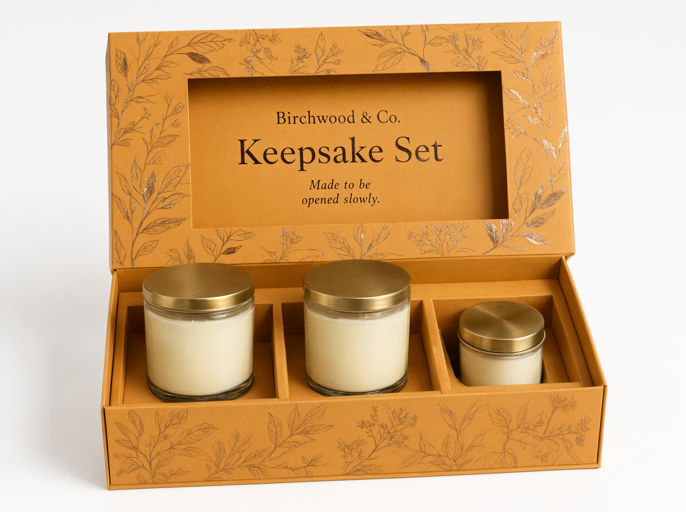 Open rigid gift box showing a die-cut divider holding two candle jars and a tin apart