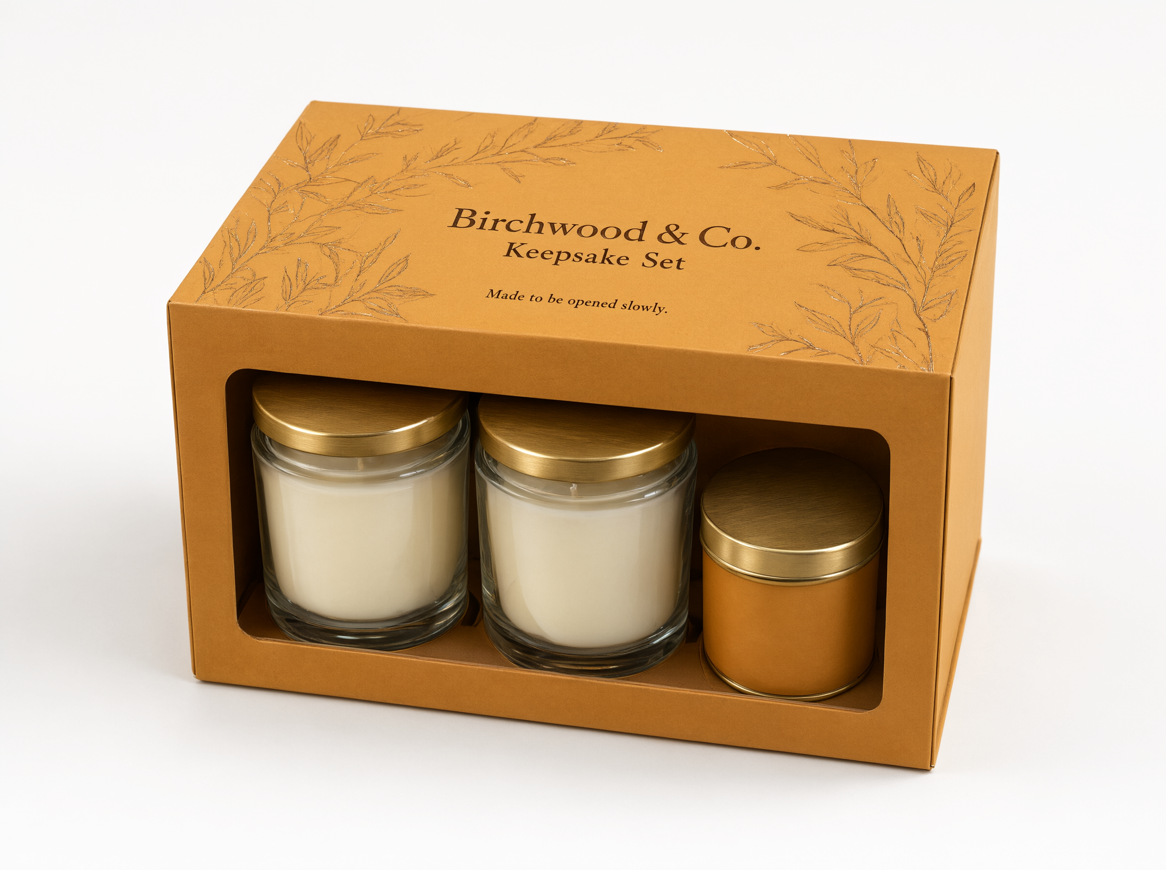 Closed honey amber rigid gift box with a window showing two candle jars and a travel tin inside