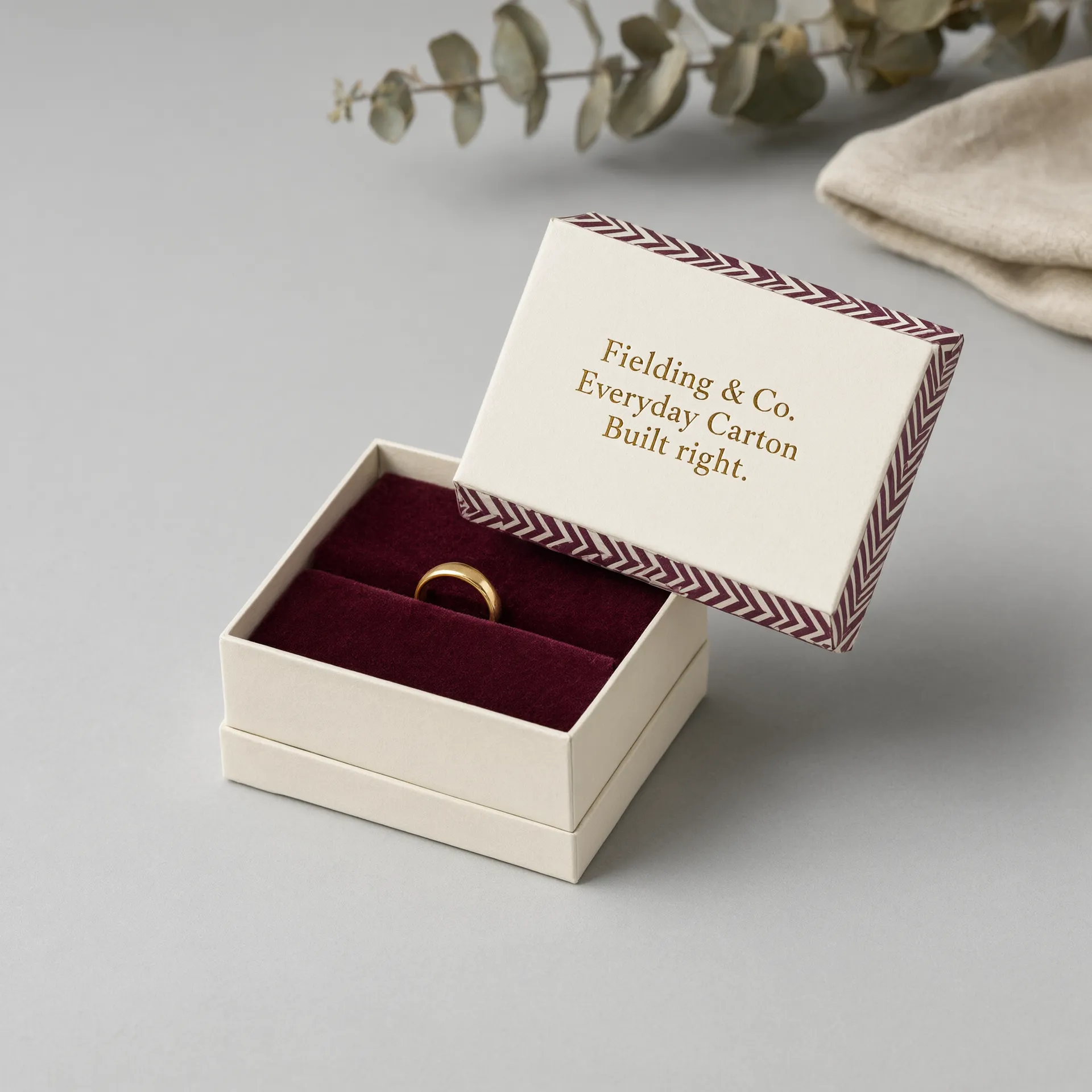 Ivory jewelry box styled with lid lifted, showing the ring presentation