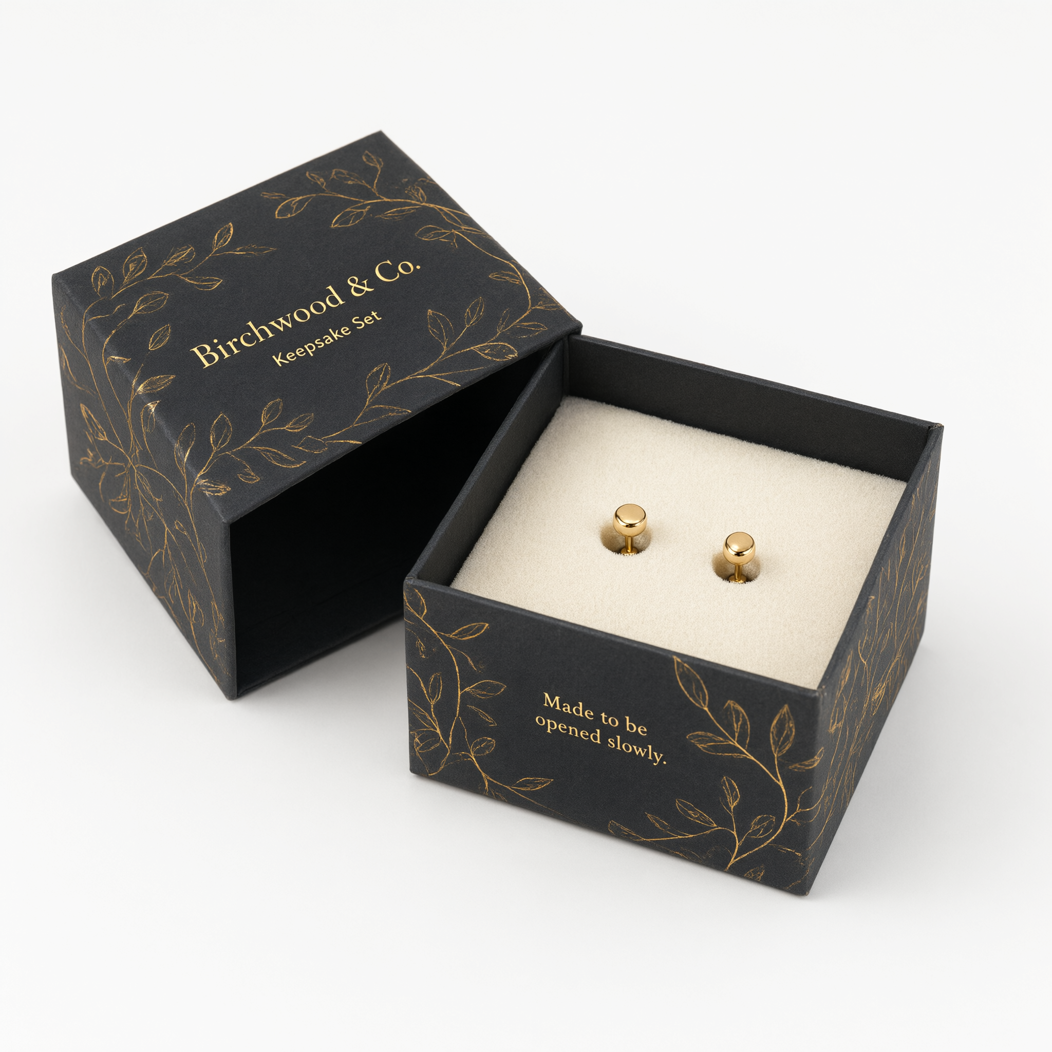 Open small rigid earring box showing a foam insert holding one pair of gold stud earrings