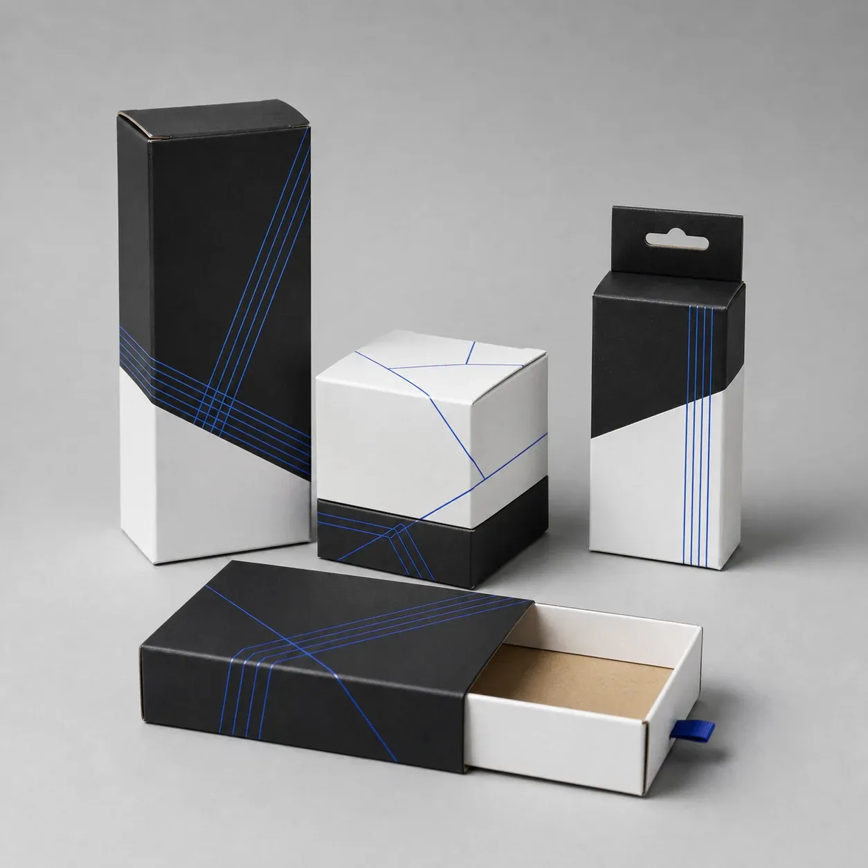 Black and white retail cartons and sleeves with cobalt line details on a gray studio set